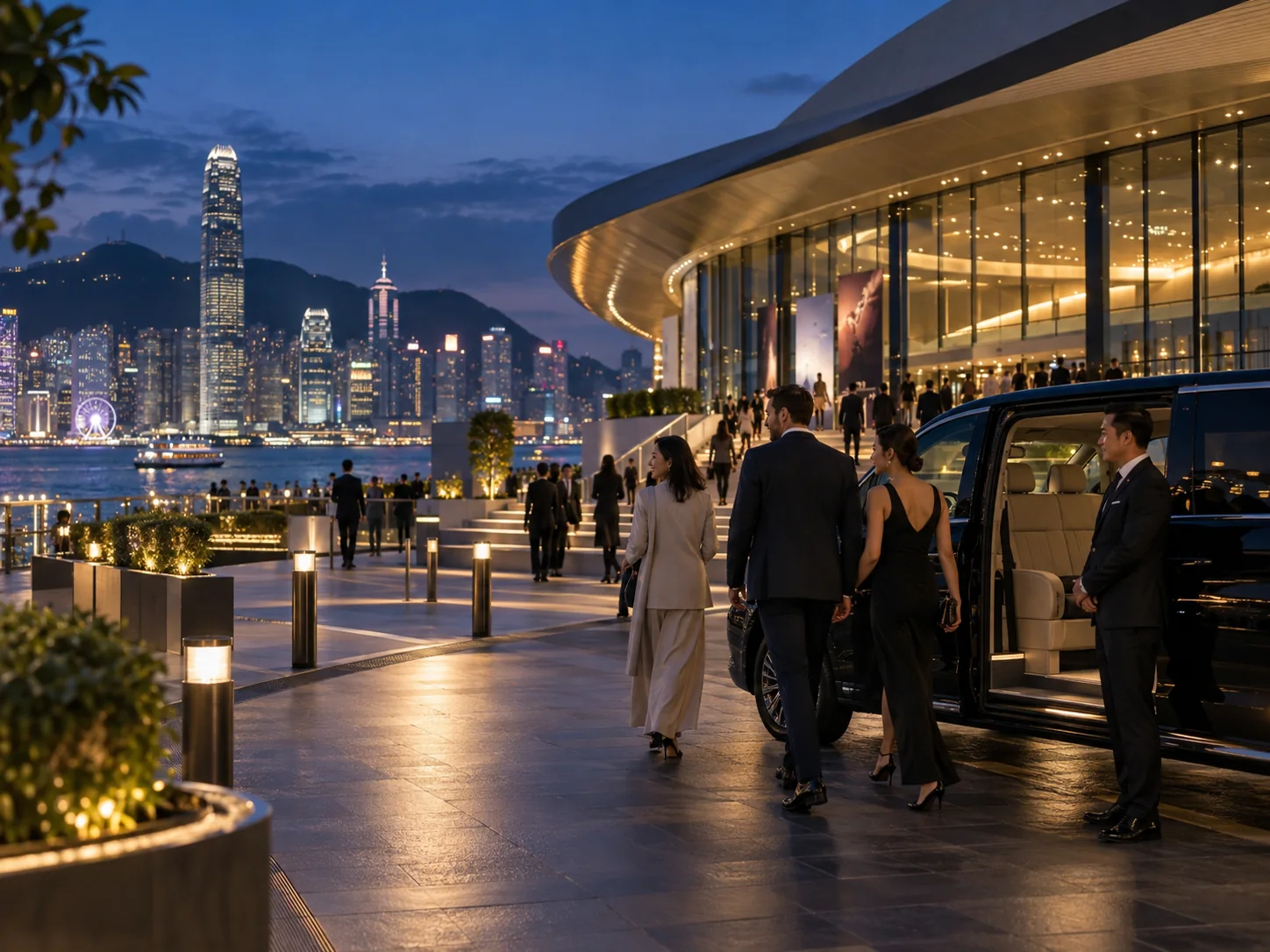 International visitors arriving at a Hong Kong waterfront event venue at blue hour